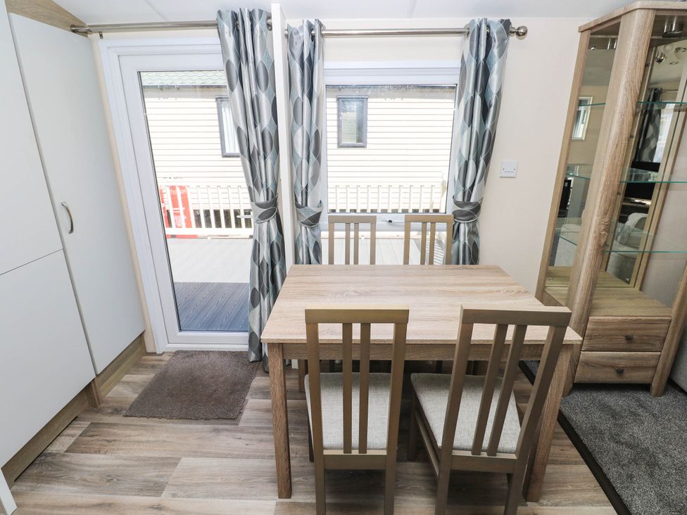 A dining room with a table and chairs at Number 19 in Ferryside