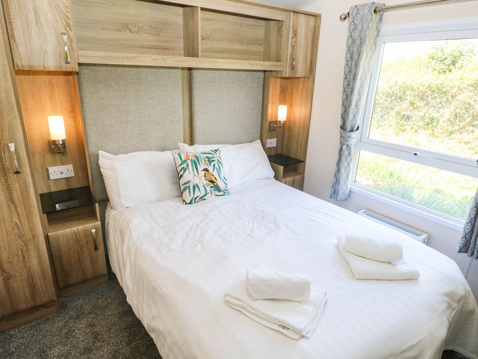 A bedroom with a bed and bedside lamp at Number 19 Ferryside