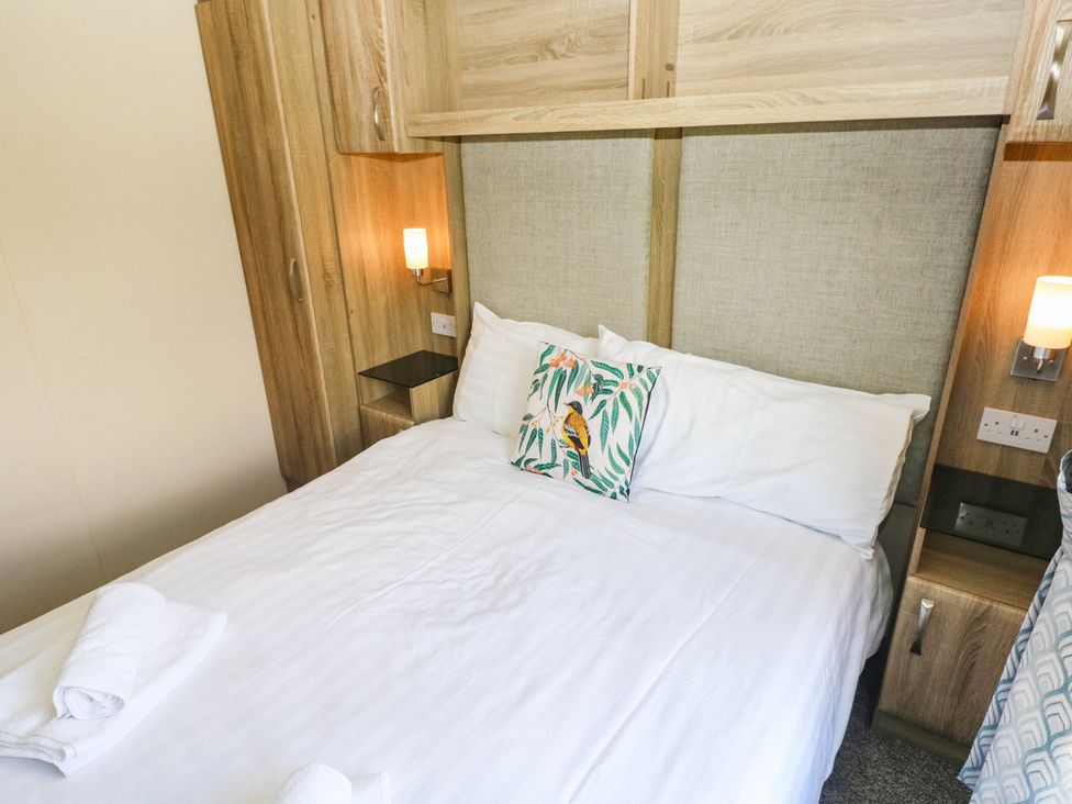A bedroom with a bed and bedside table at Number 19 Ferryside