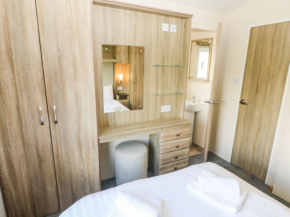 A bedroom with a wardrobe and a vanity unit at Number 19 Ferryside