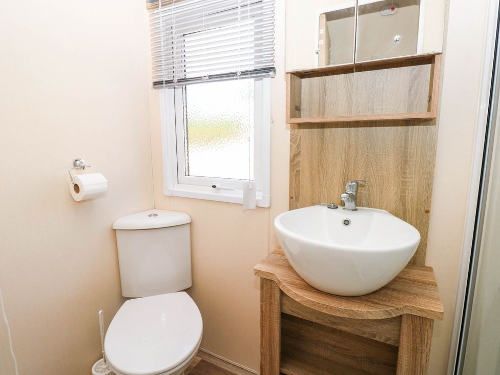 A bathroom with a toilet and sink at Number 19 in Ferryside