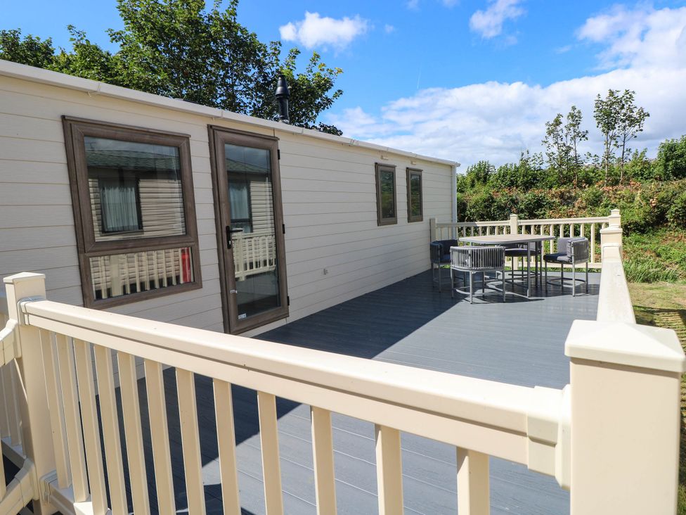 An outdoor patio with a table and chairs at Number 19 in Ferryside