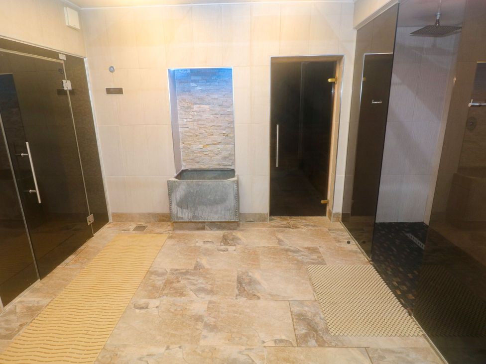 A spa area with shower and water feature at Number 19 in Ferryside