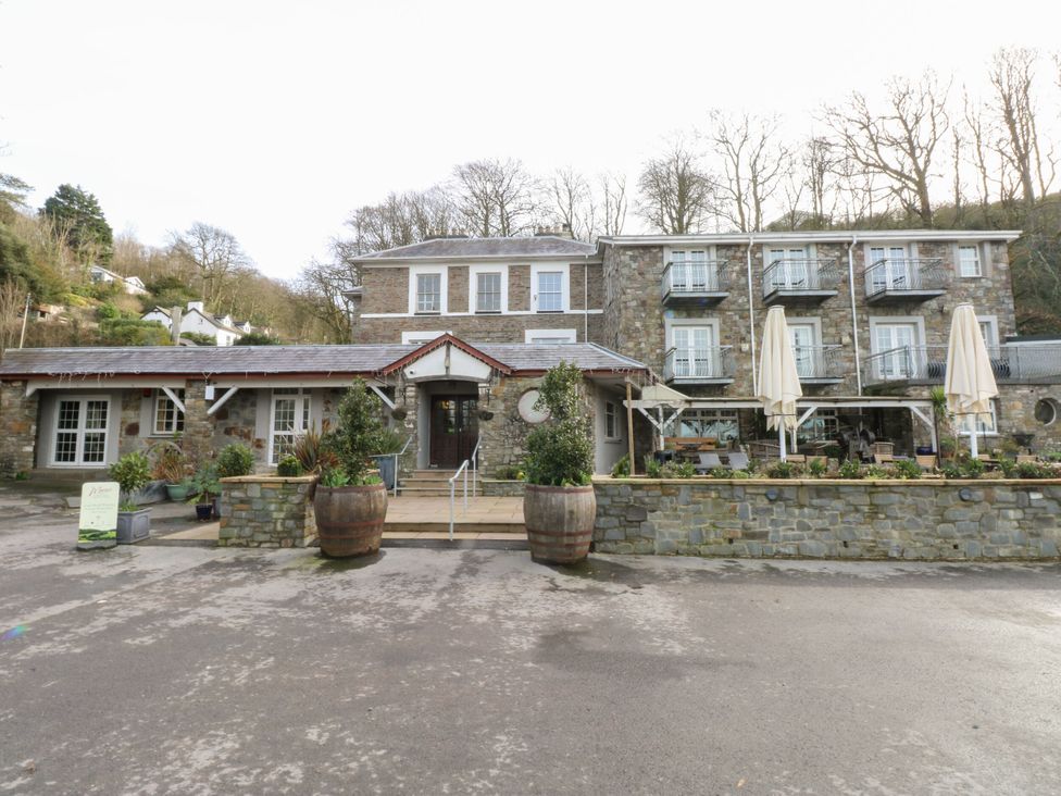 An exterior view of a stone building with umbrellas at Number 19 in Ferryside