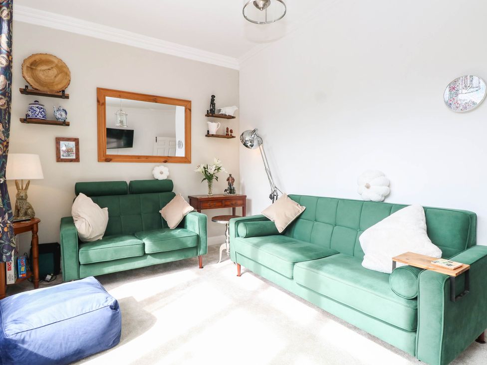 A living room with sofas, a table, and decorative items at 10 Uplands Court in Brundall