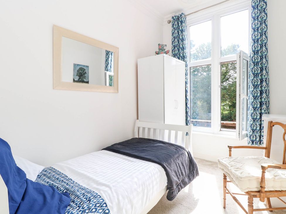A bedroom with a bed and a mirror at 10 Uplands Court Brundall