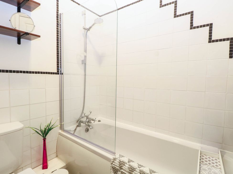 A bathroom with a bathtub and shower at 10 Uplands Court in Brundall