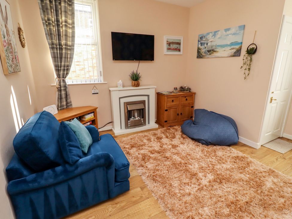 A living room with a sofa and television at The Old Bank House Red Row near Amble
