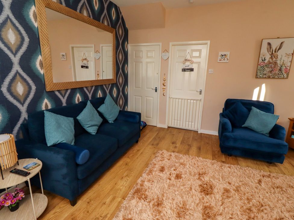 A living room with sofas and a mirror at The Old Bank House Red Row near Amble