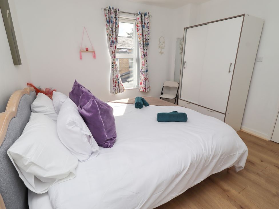 A bedroom with a bed and wardrobe at The Old Bank House in Red Row near Amble