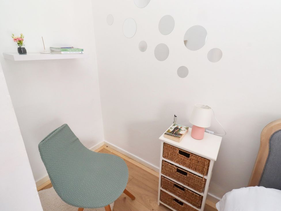 A reading corner with a chair and shelf at The Old Bank House Red Row near Amble