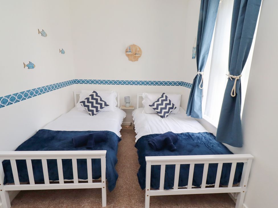 A bedroom with two single beds and decorative wall features at The Old Bank House Red Row near Amble