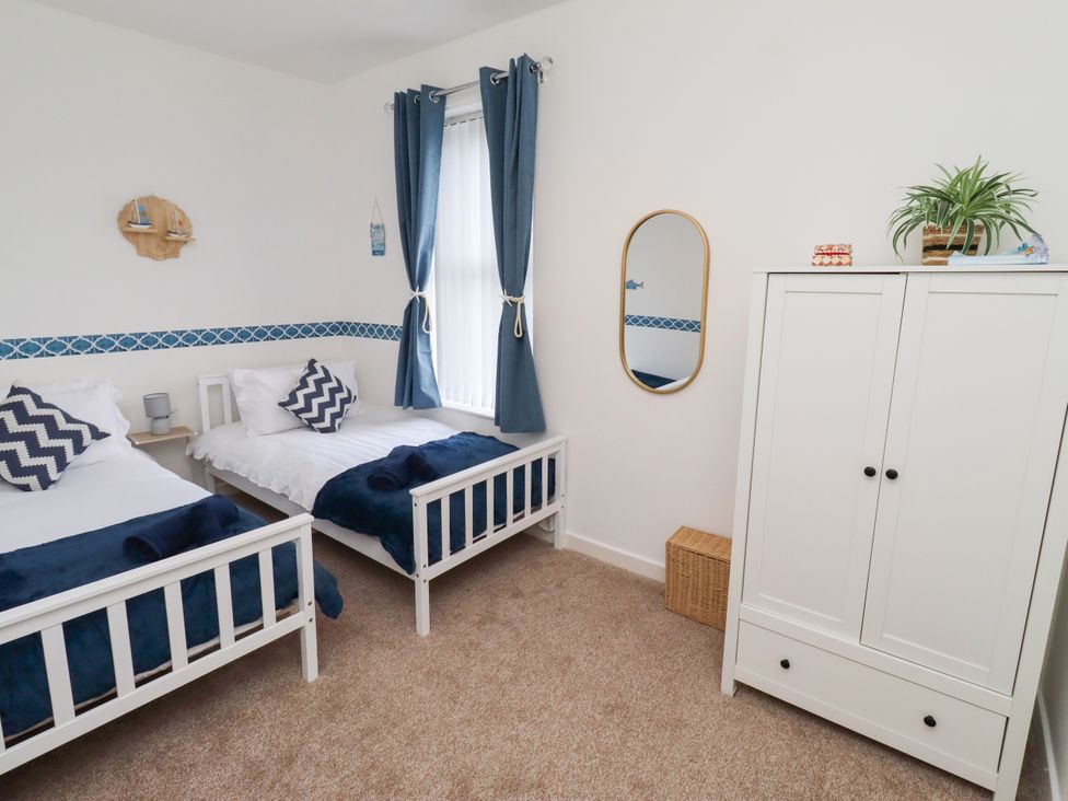 A bedroom with two beds and a wardrobe at The Old Bank House Red Row near Amble