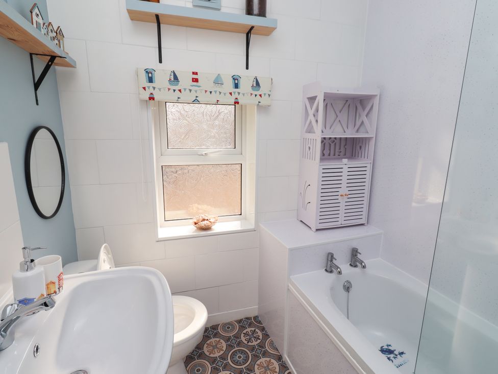 A bathroom with a sink, toilet, and bathtub at The Old Bank House Red Row near Amble