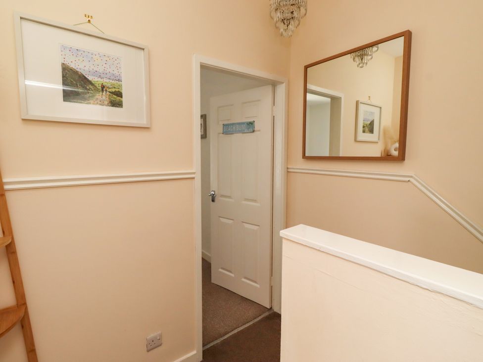 A hallway with a mirror and wall art at The Old Bank House Red Row near Amble