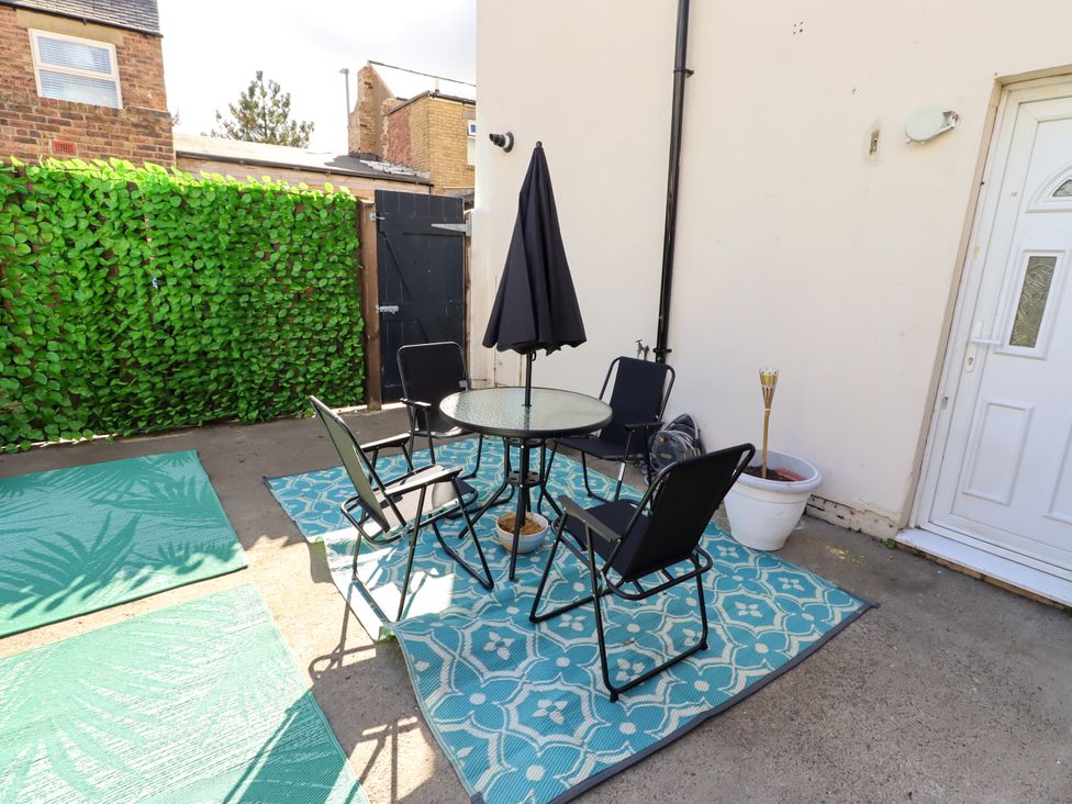 An outdoor seating area with a table and chairs at The Old Bank House Red Row near Amble