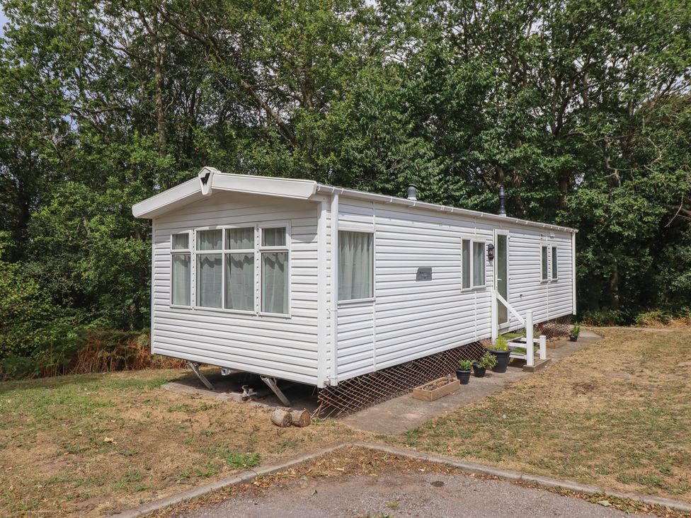 A mobile home with steps and plants at Plot 13A