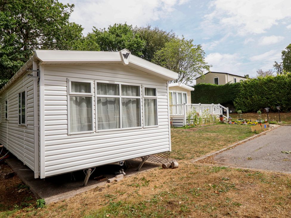 A mobile home with grass and a pathway at Plot 13A