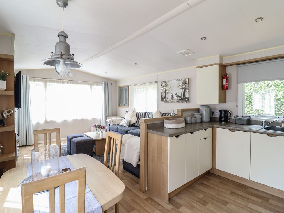 A living room with a dining area and kitchen features at Plot 13A