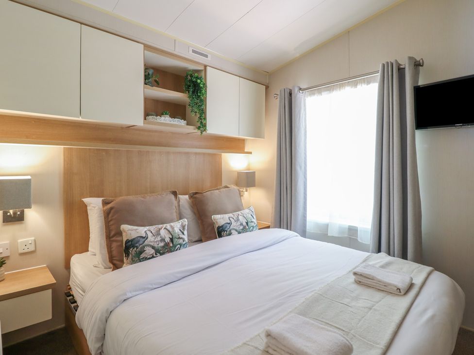 A bedroom with a bed and bedside lamps at Plot 13A 