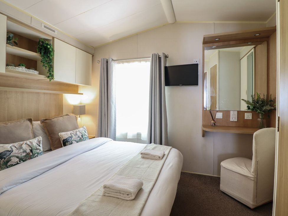 A bedroom with a bed and a mirror at Plot 13A