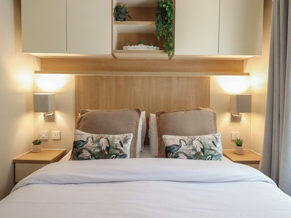 A bedroom with bed and decorative pillows at Plot 13A