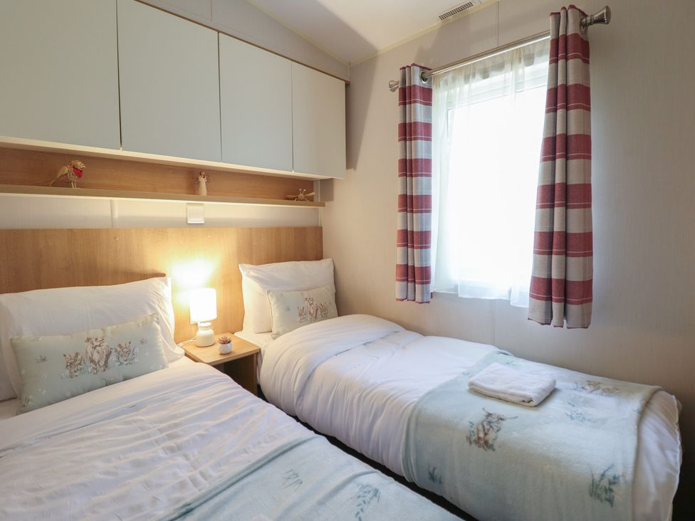 A bedroom with two beds and a window at Plot 13A