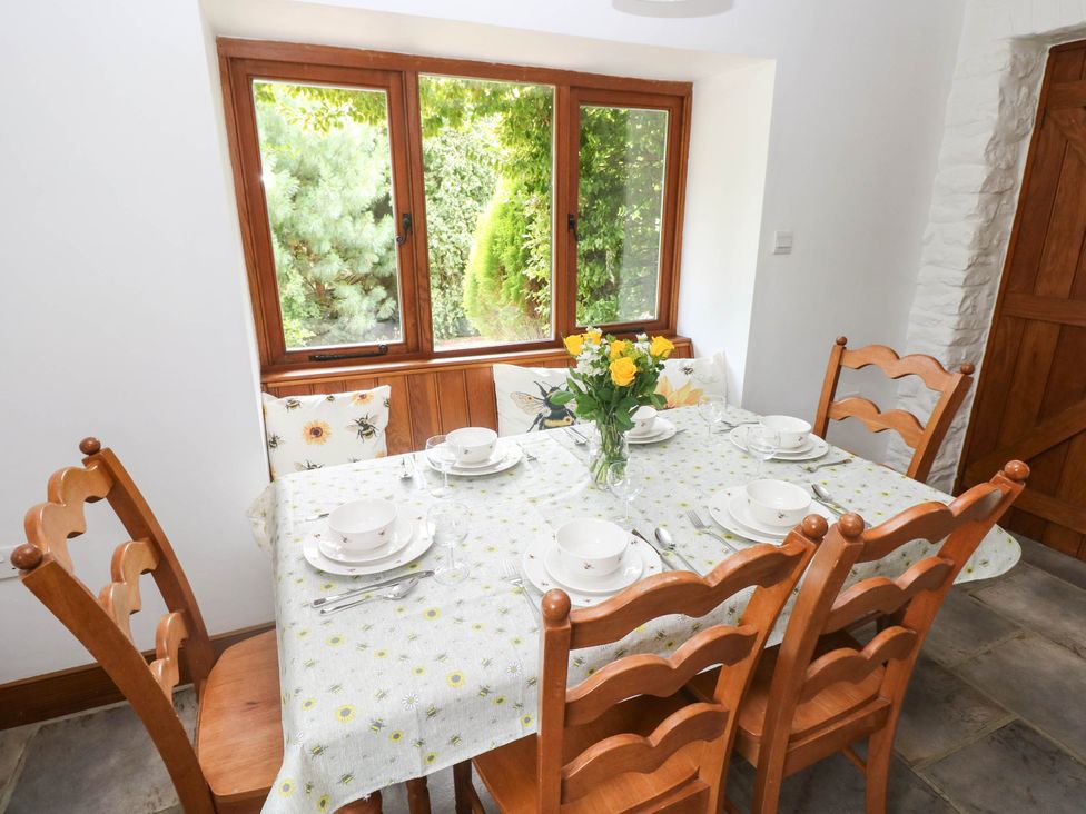 A dining room with a table and chairs at Penrhiwoli Barn Cefn Gorwydd