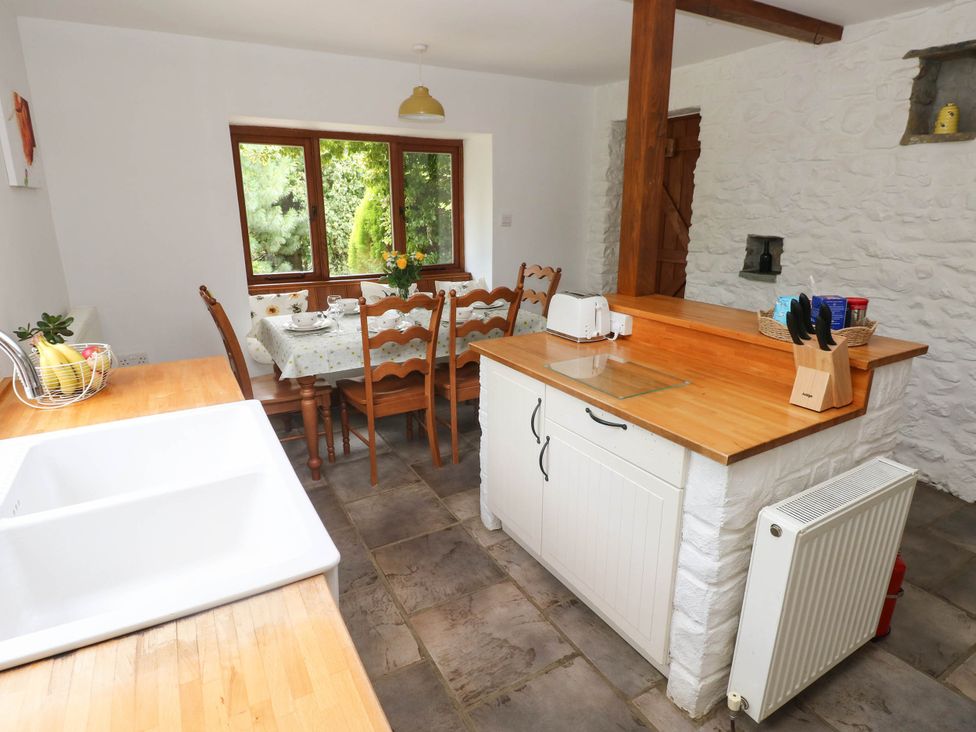 A kitchen with a dining table and chairs at Penrhiwoli Barn in Cefn Gorwydd
