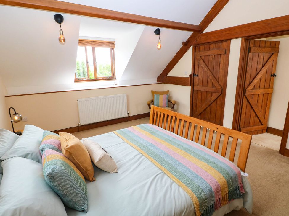 A bedroom with a bed and window at Penrhiwoli Barn in Cefn Gorwydd