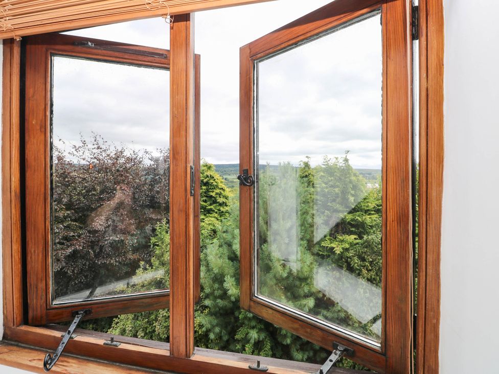 A window view of trees at Penrhiwoli Barn in Cefn Gorwydd