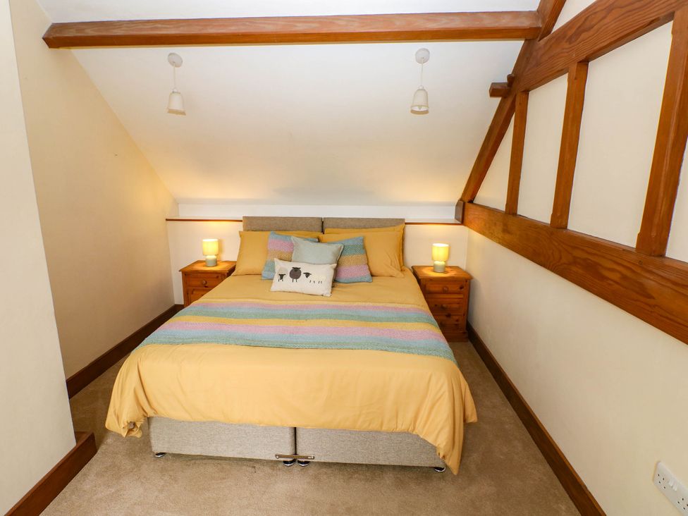 A bedroom with a double bed and bedside tables at Penrhiwoli Barn in Cefn Gorwydd