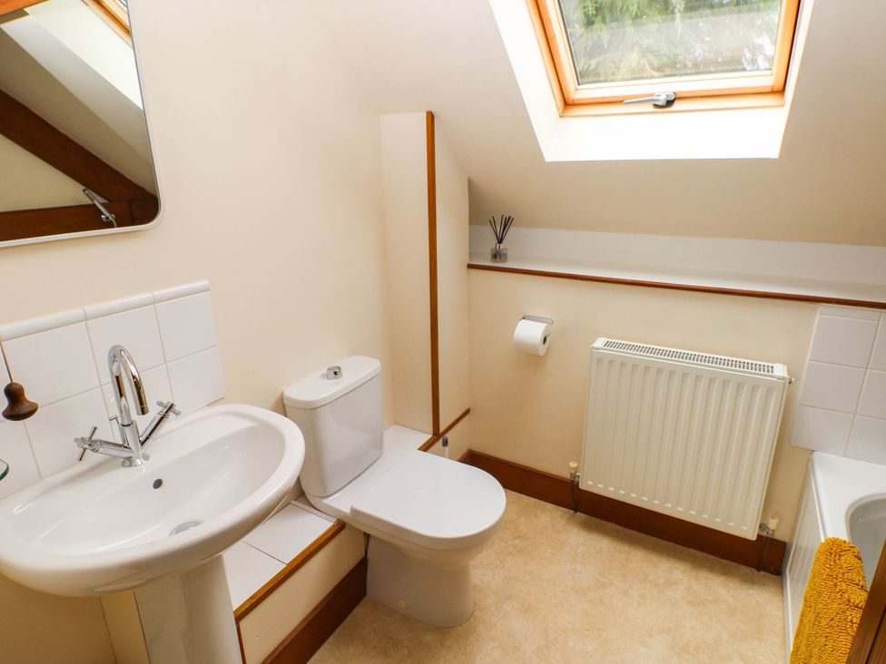 A bathroom with sink, toilet and window at Penrhiwoli Barn Cefn Gorwydd