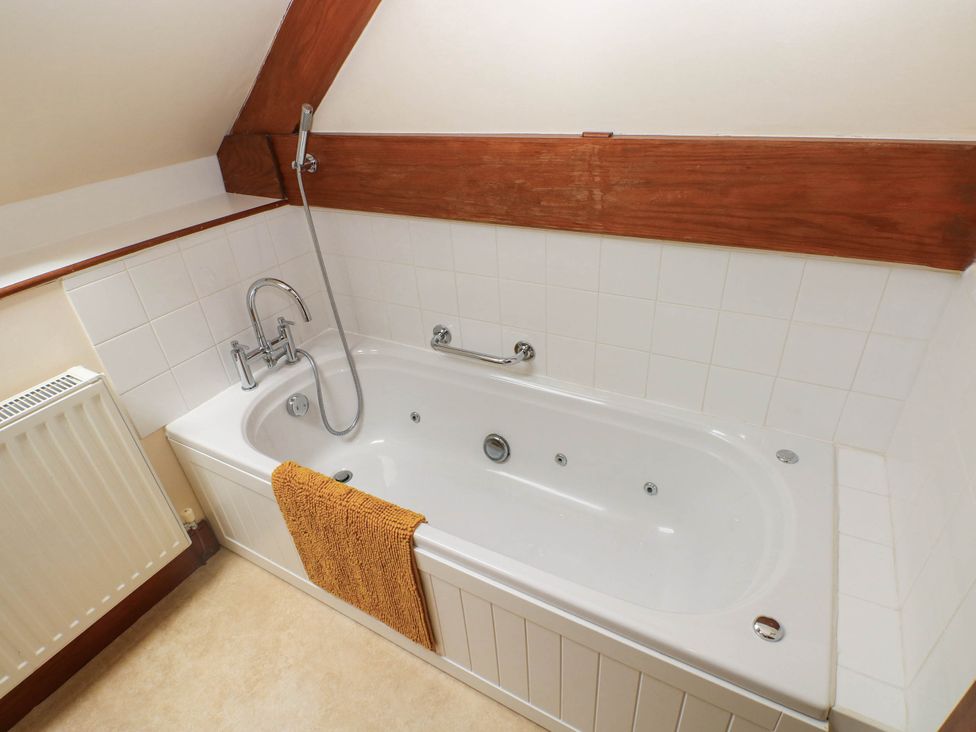 A bathroom with a bathtub and towel at Penrhiwoli Barn Cefn Gorwydd