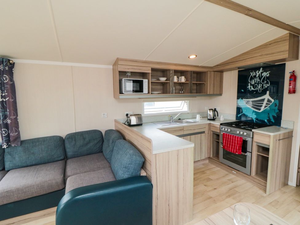 A kitchen with a sofa and appliances at 42 Oak Green
