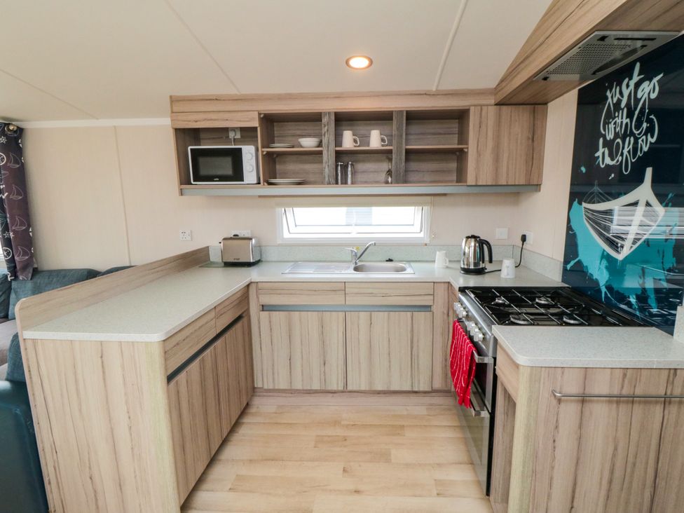 A kitchen with a sink and stove at 42 Oak Green