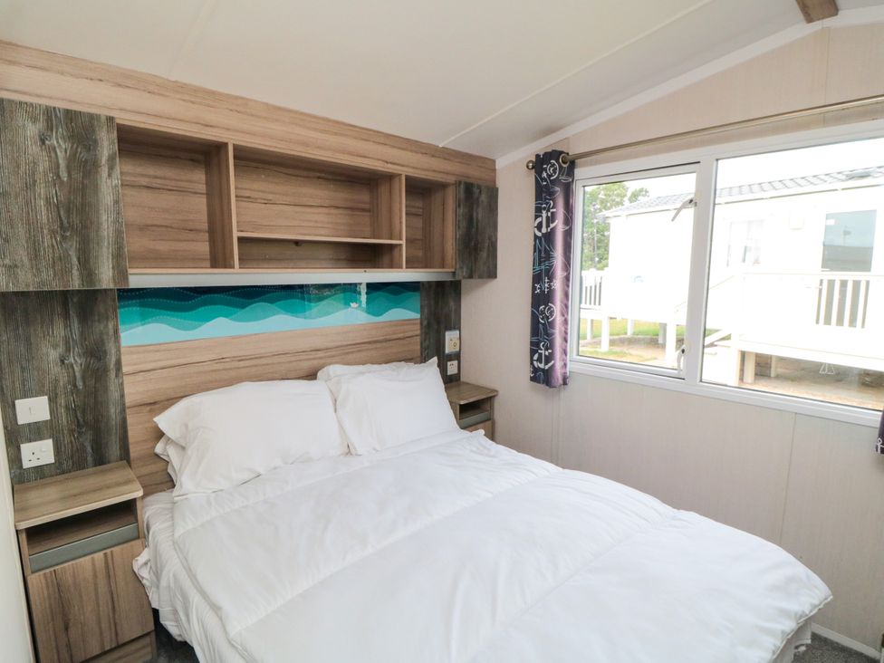 A bedroom with a bed and shelves at 42 Oak Green