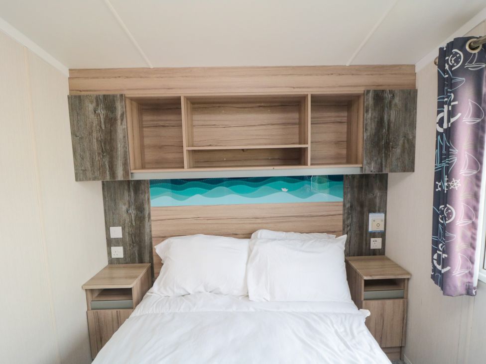 A bedroom with a bed and shelves at 42 Oak Green