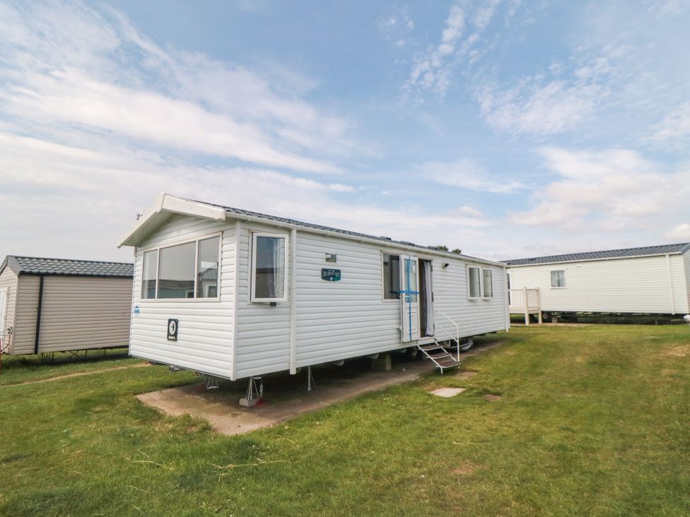 A mobile home on grass with steps at 42 Oak Green
