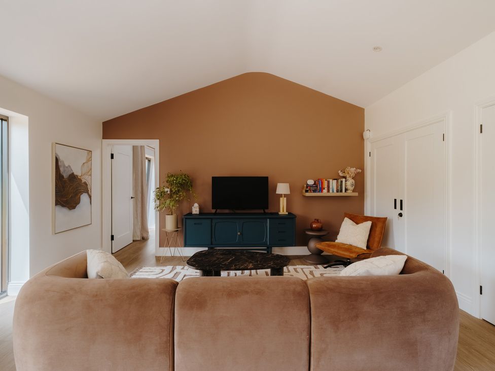 A living room with a sofa and television at Baldslow Barn in Battle near Hastings