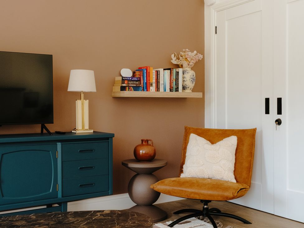 A living room with a television and books on a shelf at Baldslow Barn Battle near Hastings