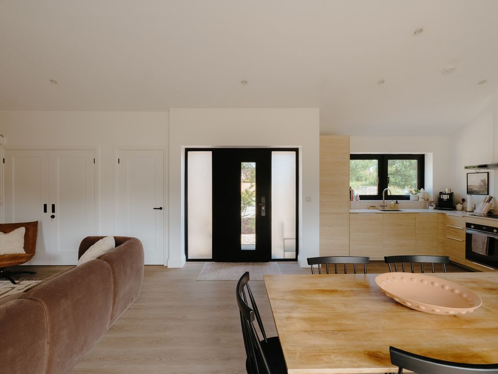A living room with kitchen area and dining table at Baldslow Barn in Battle near Hastings