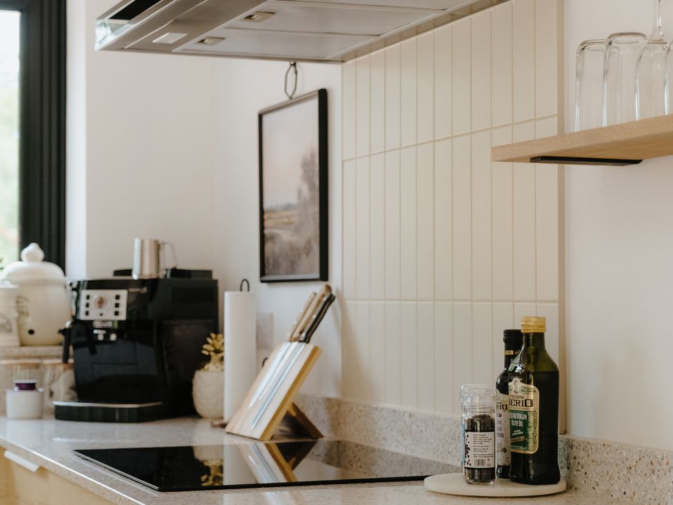 A kitchen with a coffee machine and olive oil on the countertop at Baldslow Barn near Hastings