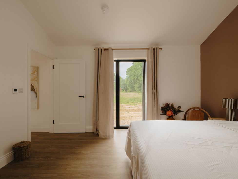 A bedroom with a bed and window at Baldslow Barn in Battle near Hastings