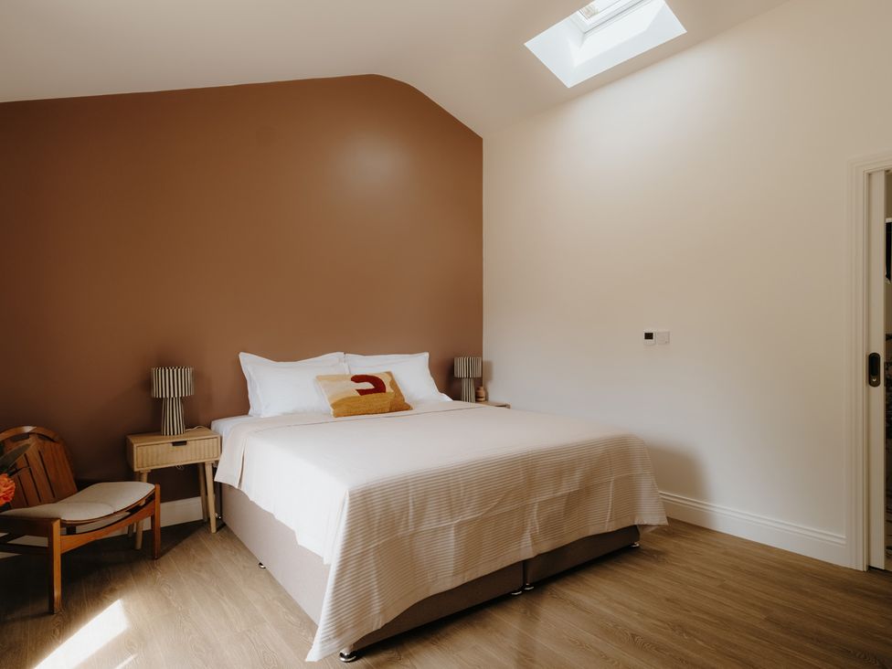 A bedroom with a bed and a bedside table at Baldslow Barn in Battle near Hastings
