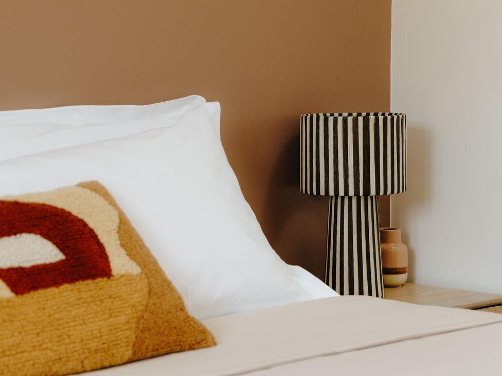 A bedroom with a bed and striped lamp at Baldslow Barn Battle near Hastings