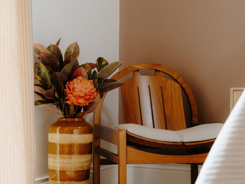 A chair with a flower vase in a corner at Baldslow Barn in Battle near Hastings