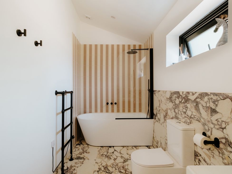 A bathroom featuring a bathtub and shower at Baldslow Barn Battle near Hastings