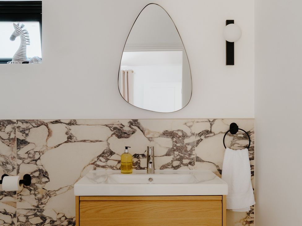 A bathroom with a sink and mirror at Baldslow Barn in Battle near Hastings