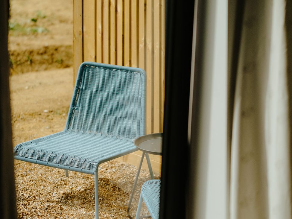 An outdoor area with a chair and table at Baldslow Barn in Battle near Hastings